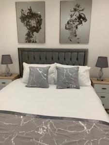 um quarto com uma cama grande com três fotografias na parede em Apartment C, a one bedroom Flat in south London em Carshalton
