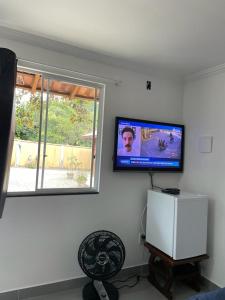 a living room with a flat screen tv on the wall at Pedacinho do céu in Cabo Frio