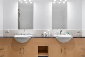a bathroom with two sinks and two mirrors at Spacious 3 Bedroom Townhouse in Cairns City in Cairns +19 photos