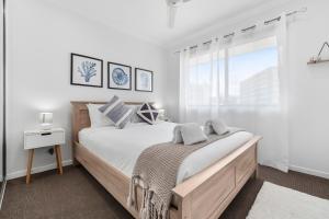 um quarto com uma cama grande e uma janela em Spacious 3 Bedroom Townhouse in Cairns City em Cairns