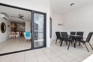 凱恩斯的住宿－Spacious 3 Bedroom Townhouse in Cairns City，用餐室以及带桌椅的起居室。