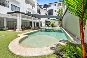 a swimming pool in the backyard of a building at Spacious 3 Bedroom Townhouse in Cairns City in Cairns