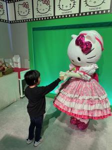 a young boy is playing with a hello kitty doll at Guesthouse RETURN in Kitsuki