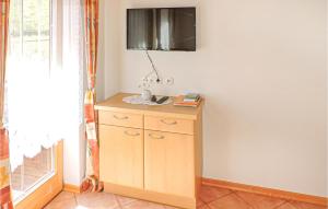 カルティッシュにあるNice Apartment In Kartitsch With 2 Bedrooms And Wifiのキャビネット付きの客室で、壁にテレビが備わります。