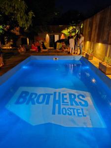 a blue swimming pool with the brothers united logo on it at BROTHERS HOSTEL in Villa Allende