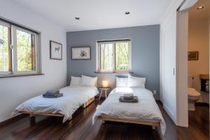 two beds in a room with two windows at Forest Hideaway - Vacation STAY 09982v in Niseko