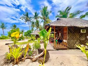 a hut on the beach with palm trees at Marahuyo Siargao in Catangnan +17 photos