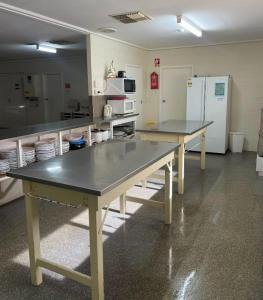 a kitchen with two tables and a refrigerator at Tuckerway - Beach Stay Property for Large Groups! in Port Vincent