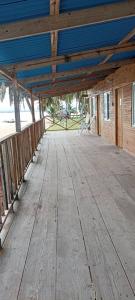 a wooden porch with a blue roof on a building at hospedaje en las islas de San blas habitacion privado con baño compartido in Achoertupo