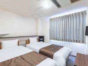 a hotel room with two beds and a window at Tabist New Gekkoen in Shimminatomachi