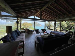 una sala de estar con sofás y vistas al agua. en 7suítes-Cond fechado-Vista p/Barra do Sahy-16 pes. en Barra do Sahy