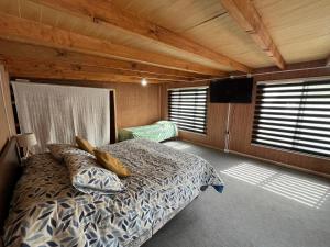 a bedroom with a bed and a flat screen tv at Cabaña Kora in Puerto Fuy