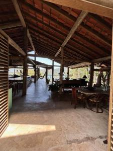 un pabellón con mesas y sillas y techo de madera en 7suítes-Cond fechado-Vista p/Barra do Sahy-16 pes. en Barra do Sahy