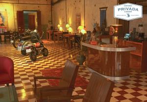 un restaurant avec des motos garées dans une salle avec des tables dans l'établissement PRIVADA LODGE, à Kratie