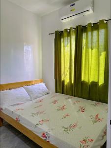 a bedroom with a bed with a green curtain at My Lovely Apartment in Dipolog