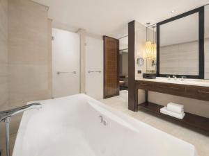 Sheraton Shanghai Jiading Hotel في Jiading: حمام مع حوض أبيض كبير ومغسلة