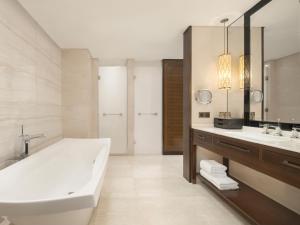 a bathroom with a tub and a sink and a mirror at Sheraton Shanghai Jiading Hotel in Jiading