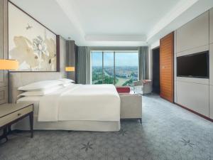 嘉定区にあるシェラトン 上海 嘉定 ホテルのベッドとテレビが備わるホテルルームです。