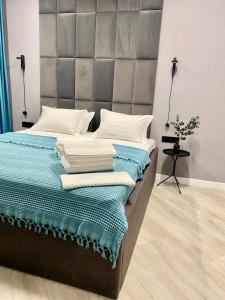 a bedroom with a large bed with blue and white sheets at Landmark Astana 2 комнатные апартаменты in Astana