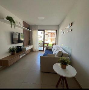 a living room with a couch and a table at Village OAHU Imbassaí in Matta de São João
