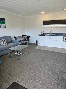 a living room with a couch and a table at Beach Street Motel Apartments in New Plymouth