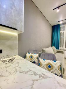 a bedroom with a large bed and two chairs at Landmark Astana 2 комнатные апартаменты in Astana