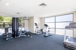 einen Fitnessraum mit Laufbändern und Trainingsgeräten in einem Gebäude in der Unterkunft 514 Oaks Pacific Blue Townhouse in Salamander Bay