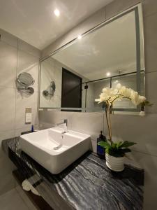 Bertam Resort,Penang في كيبالا باتاس: حمام مع حوض أبيض ومرآة