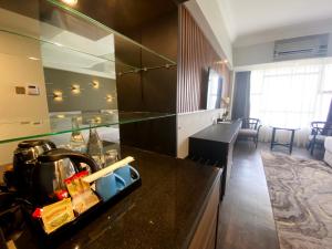 a kitchen with a counter top and a living room at Bertam Resort,Penang in Kepala Batas