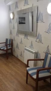 een kamer met twee stoelen en een muur met boten erop bij Isabel in Cudillero