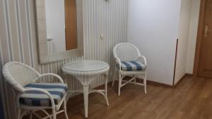 mesa, 2 sillas, mesa y espejo en Hotel Isabel, en Cudillero