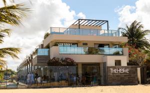 a building on the beach with people on the balcony at The Home São Miguel do Gostoso by Liiv in São Miguel do Gostoso