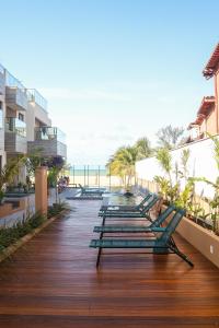 a row of chaise lounges on a boardwalk near the ocean at The Home São Miguel do Gostoso by Liiv in São Miguel do Gostoso