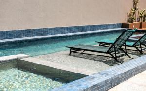 duas cadeiras sentadas ao lado de uma piscina em The Home São Miguel do Gostoso by Liiv em São Miguel do Gostoso