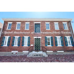un edificio di mattoni con un cartello sulla parte anteriore di Bischoff Inn - Former 1870 Furniture Factory Now 5 Room Boutique Hotel a Tamaqua