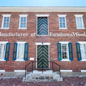 un edificio in mattoni rossi con finestre blu e verdi di Bischoff Inn - Former 1870 Furniture Factory Now 5 Room Boutique Hotel a Tamaqua