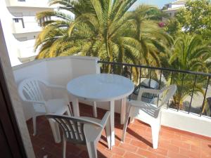 ein Tisch und Stühle auf einem Balkon mit Palmen in der Unterkunft Casa Ameijeira in Lagos + 2 Fotos