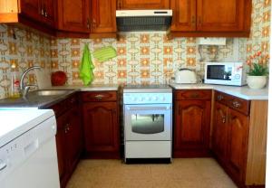 a kitchen with wooden cabinets and a white stove top oven at Casa Ameijeira in Lagos