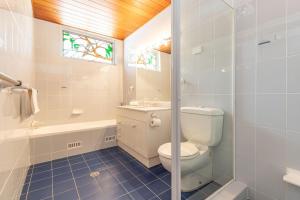 a bathroom with a toilet and a sink and a window at Coastal Cove in Smiths Lake +25 photos