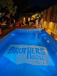 una piscina azul con los hermanos logotipo unido en ella en BROTHERS HOSTEl en Villa Allende