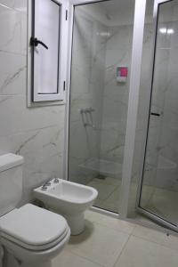 y baño con aseo y ducha acristalada. en BROTHERS HOSTEl en Villa Allende
