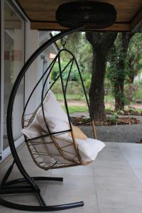 una silla colgante con almohadas en el porche en BROTHERS HOSTEl en Villa Allende