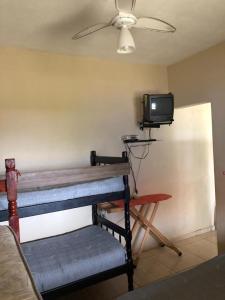 ein Zimmer mit einem Fernseher und einem Tisch und einem Stuhl in der Unterkunft Apartamentos Ilha Comprida in Ilha Comprida