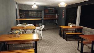 een eetkamer met houten tafels en witte stoelen bij Los Ceibos dpto para 4 personas in Estancia Vieja