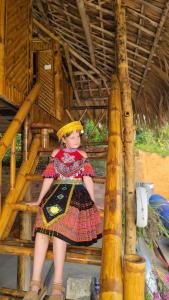 a little girl in a dress sitting on a platform at Lakeview Homestay Vu Linh in Yen Bai