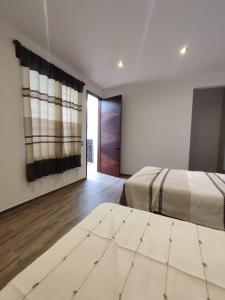 Un pat sau paturi într-o cameră la Casa Mictlan. Habitaciones en el Centro de Mitla.