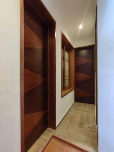 - un couloir avec des portes en bois et du parquet dans l'établissement Casa Mictlan. Habitaciones en el Centro de Mitla., à San Pablo Villa de Mitla
