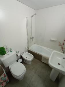 a bathroom with a toilet and a sink and a shower at Mi Lugar en Rosario - Depto céntrico VIP, 3 amb con cochera opcional in Rosario