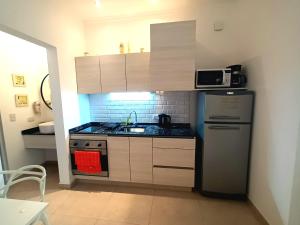 a small kitchen with a refrigerator and a sink at Depto SomoS in Colón