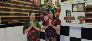 dos mujeres frente a un mostrador con las manos dobladas en 1000 Dream Bungalow en Lovina